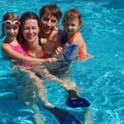 Happy family with kids in pool having fun, summer vacation
